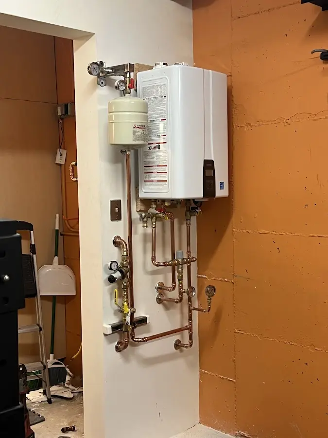 Plumbing technician inspecting water heater connections in North Royalton